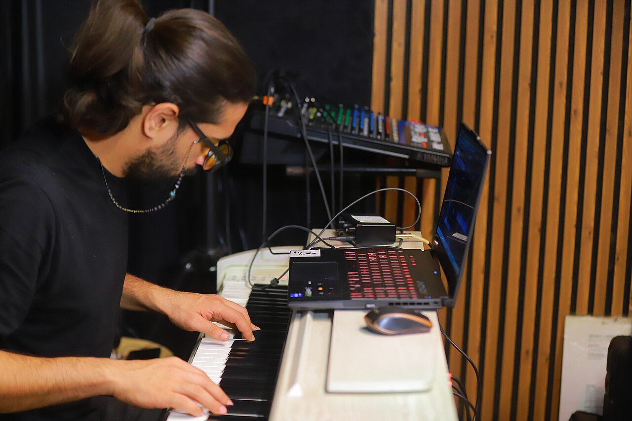 Musician playing keyboards during a band rehearsal