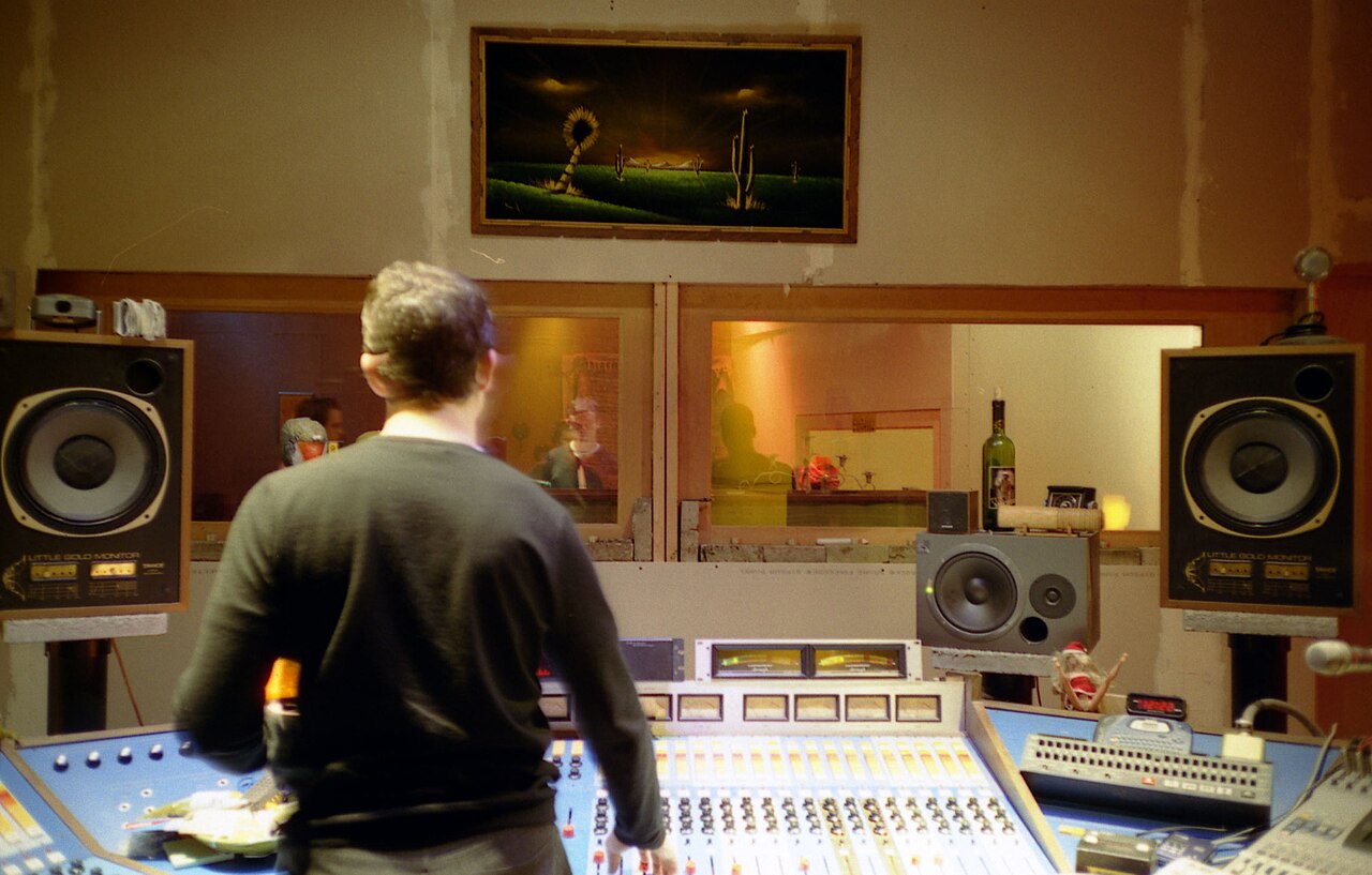 Sound engineer seated at a studio mixing console