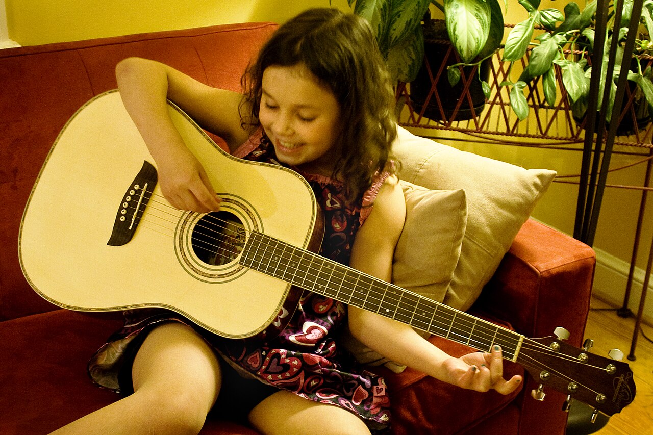 Guitarist practicing an acoustic guitar at home
