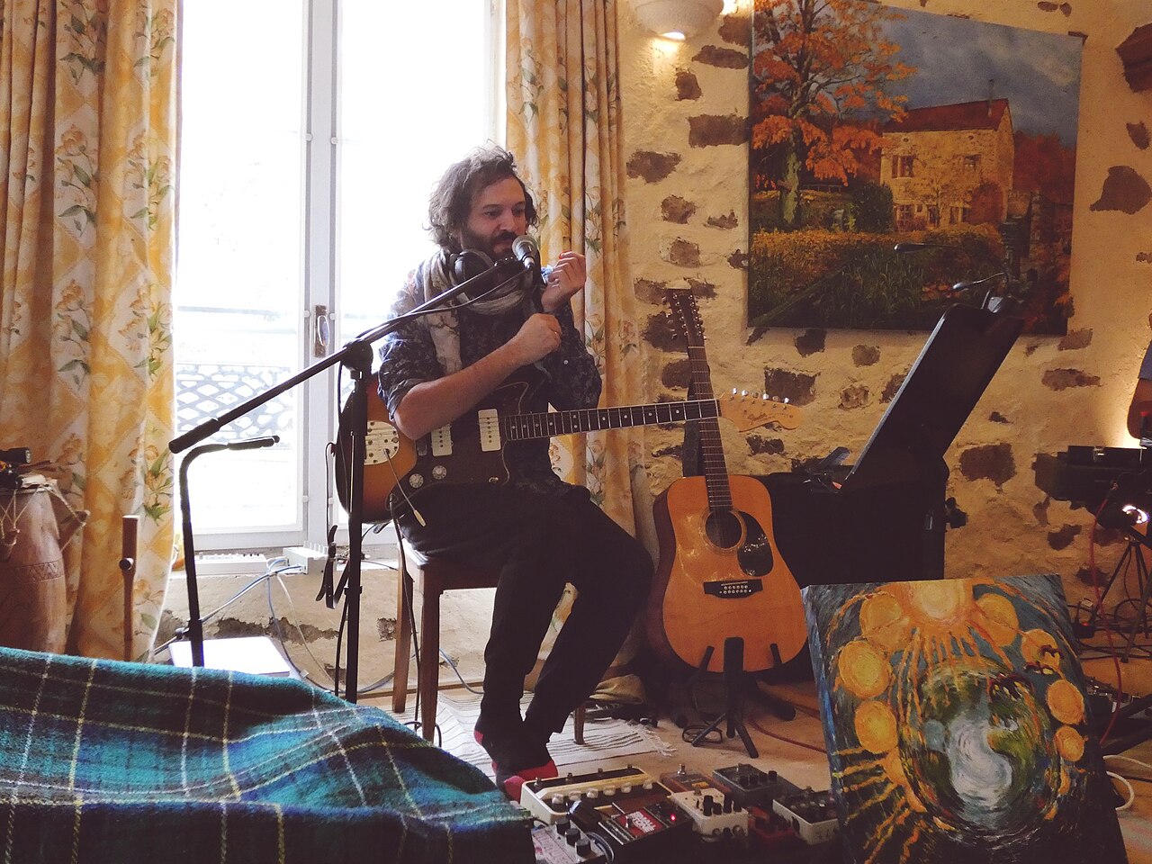 Acoustic guitarist recording at a microphone